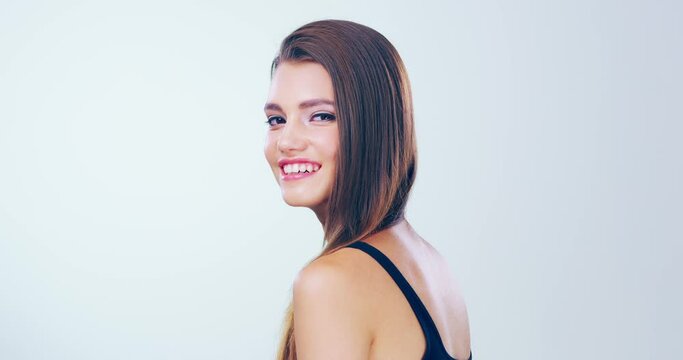 Straightening makes a huge difference. 4k video footage of a beautiful young woman with gorgeous hair posing in the studio.