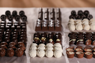 Many delicious chocolate candies on table, closeup. Production line