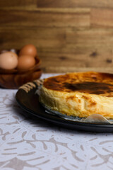 Creamy cheesecake with eggs and milk on brown and white background