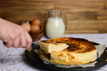 Creamy cheesecake with eggs and milk on brown and white background