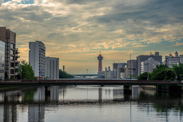 Fototapeta na wymiar 川と夕日と赤い塔