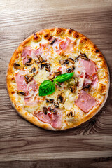 pizza with Mozzarella cheese, ham, mushrooms, onion. Italian pizza on wooden table background