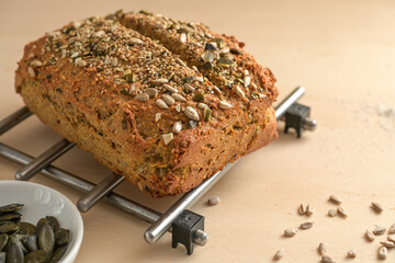 Homemade bread from whole grain flour and seeds on a grid and on a wooden table, healthy eating...