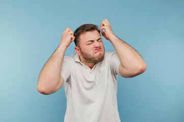 Angry man with bristles in despair isolated blue background wearing white t-shirt. Angry man...