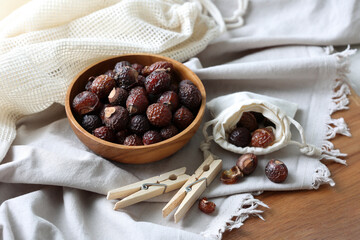 Soap nuts or soap berrys (sapindus mukorossi)  with linen and clothespins in the environmentally...