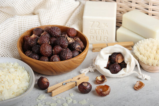 Soap nuts or soap berrys with linen, hard soap bars and clothespins in the environmentally friendly house close up. Natural laundry detergent, zero waste and eco friendly.
