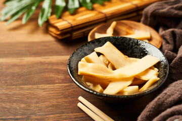 Ajitsuke Menma Pickled Bamboo Shoot in a wood dish on wooden table background with copy space      ...