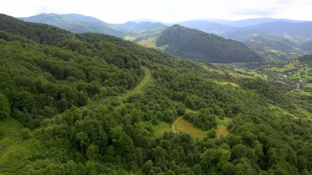 Railway from a bird's eye view passing through the green forest. Filmed in 4k, drone video.