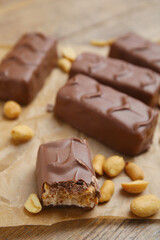 Chocolate bars with caramel, nuts and nougat on table