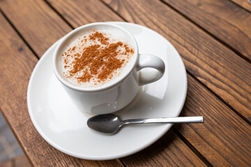 Cup of turkish traditional winter beverage Salep (Sahlep or sahlab) served with cinnamon on top in Istanbul cafe