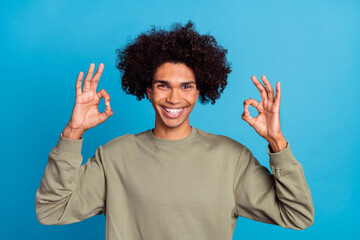Photo of young guy show fingers okey symbol promo decision perfect isolated over blue color...