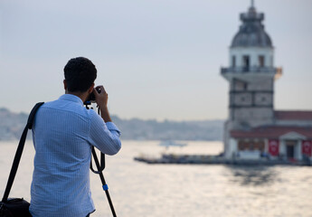 Fototapeta premium A male photographer taking pictures of the Maiden's Tower in İstanbul.