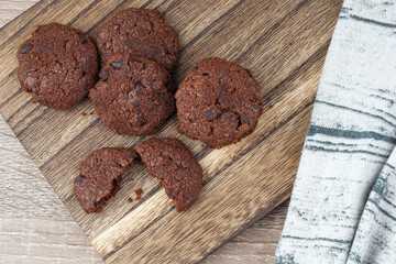 Flat lay dark chocolate cookies on a chopping board