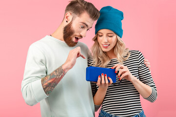young attractive couple listening to music on wireless speaker