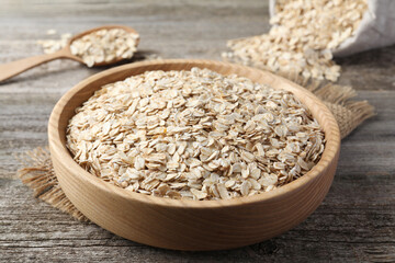 Bowl with raw oatmeal on wooden table