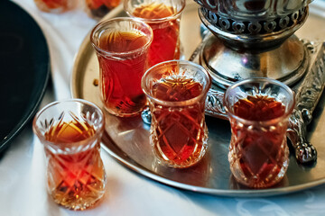 Tea in national Turkish glass glasses on a tray, next to the samovar