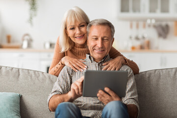 Senior Husband And Wife Using Digital Tablet Together At Home