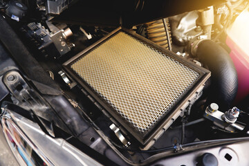 Car air filter on the air filter slot in the car engine system with a sunlight, Automotive parts...