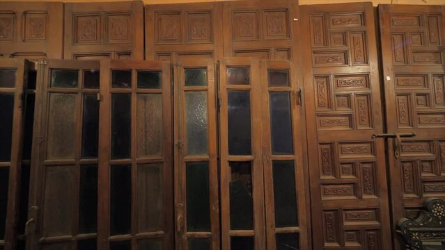 Zooming video of an old antique brown wooden doors with glass and rusted iron fittings. Beautiful Arabic house door.