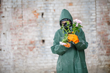 A dosimetrist scientist radiation inspector in protective clothing and a gas mask examines the...