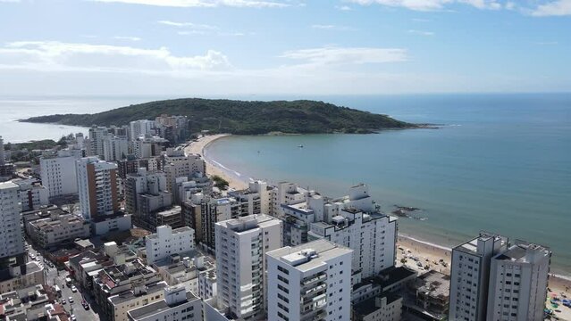 Imagens a&eacute;reas da Praia do morro em um dia ensolarado e alegre de temporada de ver&atilde;o, com crian&ccedil;as brincando da praia e barraquinhas de sol.
