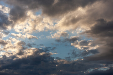 Clear Bluish Sky, Shining by the Sun, in the Middle of a Cloudy Sky. Hope, Optimism. Copy space. Background. High quality photo