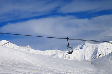 Fototapeta na wymiar Chair lift and off-piste slope at nice day