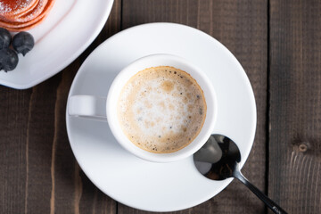 Cafe espresso macchiato layered coffee in a see through white glass coffee cup.