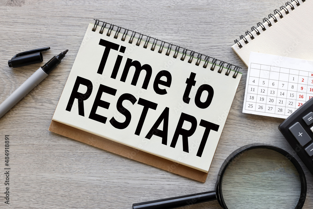 Poster time to restart . open notepad with text on a rustic background. business concept