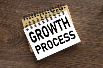 GROWTH PROCESS . two notebooks with a spring on a wooden background