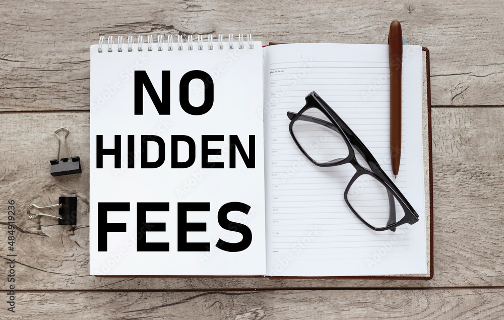 Poster no hidden fees. text on an open notepad on a wooden table near a magnifying glass and money