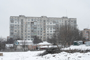 Old Soviet prefabricated nine-storey panel apartment building in winter.