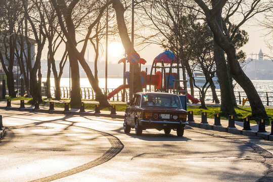 A vintage car on the road in sunny weather with Istanbul city view in the background.