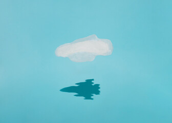 Sanitary pad flies on a blue background with the shadow of an airplane. Minimal lay out composition.
