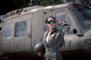 Portrait beautiful soldier women wearing navy soldier uniform ,sunglass and helmet posing by soldier car truck background.