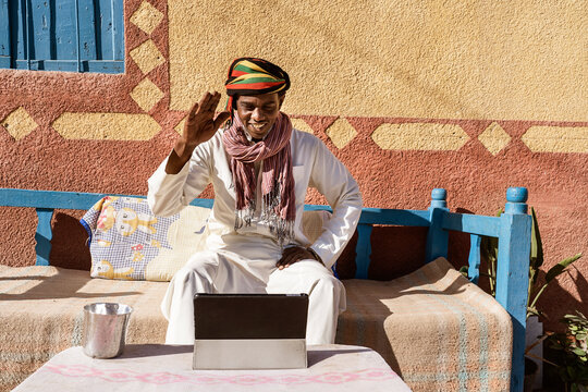 Arab man talking on video call via tablet in countryside