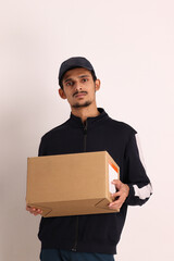 unshaven Indian courier boy with brown box wearing black t-shirt with facial expressions isolated on white background 