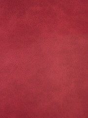 Burgundy suede surface textured as a background. High quality photo