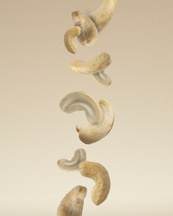 Close up photo of floating raw organic cashews on beige background.