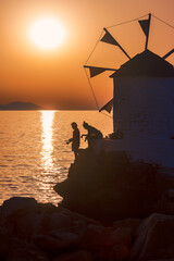 Zwei Jugendliche angeln im Sonnenuntergang in Aegiali auf der griechischen Insel Amorgos