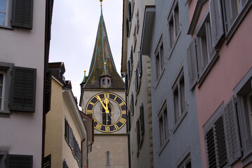 Fototapeta na wymiar Medieval old town of Zürich with protestant church St. Peter in the background on a cloudy winter day. Photo taken February 1st, 2022, Zurich, Switzerland.