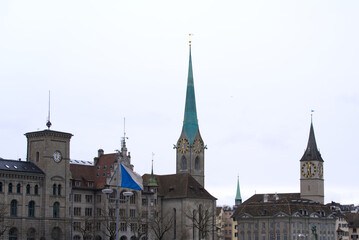 Protestant churches Women's Minster and St. Peter with river Limmat in the foreground at the old town of Zürich on a gray winter day. Photo taken February 1st, 2022, Zurich, Switzerland.