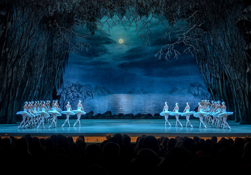 Classical ballet on stage of Theater. Ballet dancers on stage dance classical works. Form of artistic ball dance on stage of theater.