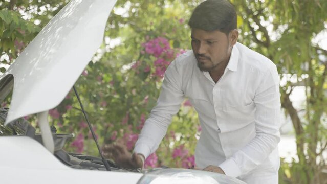 Confused or worried taxi driver checking breakdown car - concept of problems while travelling, transportation and maintenance
