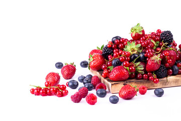 Ripe berries mixed assortment on wooden board on white background. Summer berries background. Cloce up image with copy space.