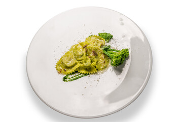 Green ravioli with turnip greens (cime di rape) and anchovy in white plate isolated on the white