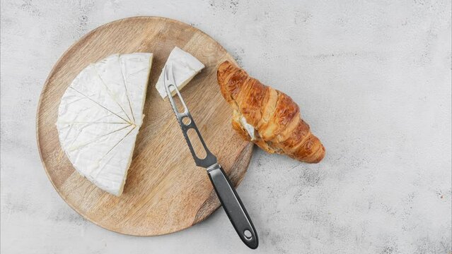 Round cheese and brioche on a wooden plate.
Organic products, online market. stop motion animation, slow motion. 4k
