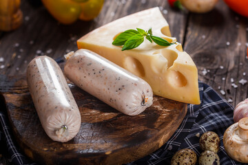 Homemade food, sausage with chicken pate, hard cheese, kitchen cutting board, cherry tomatoes and...