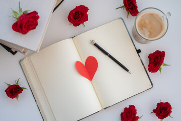 Valentine's Day red heart on an empty notebook with flowers and coffee
