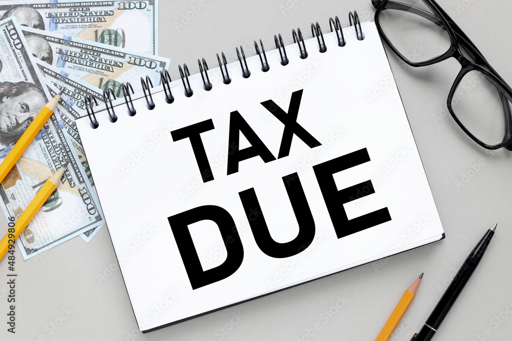 Poster tax due text on an open notebook with a spiral on a gray background